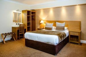 una habitación de hotel con una cama y un escritorio en Adamson Hotel, en Dunfermline