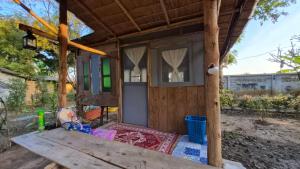 a tiny house with a porch and a window at Faiza Farm home in Ban Nong Phai