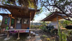 a small house with a bench in front of it at Faiza Farm home in Ban Nong Phai