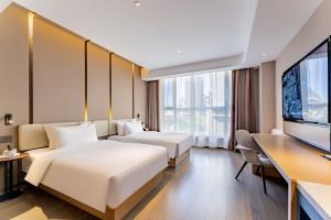 a hotel room with two beds and a flat screen tv at Mercure Huhhot Economic Zone in Hohhot +27 photos