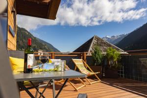 a bottle of wine sitting on a table on a deck at Art-Apartments Kartnaller superior in Neustift im Stubaital