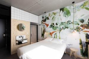 ein Schlafzimmer mit einem weißen Bett und einer floralen Wand in der Unterkunft MOLOKO at de Melkhal - just a room - digital key by SMS in Enschede