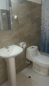 ein Badezimmer mit einem weißen Waschbecken und einem WC in der Unterkunft Las Tortuguitas Bungalows in Los Órganos