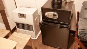 a microwave and a refrigerator next to a table at 66 Lodge Country Station in Kimobetsu