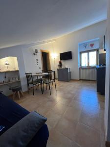 een woonkamer met een tafel en stoelen en een keuken bij Roccaraso Inn Blu in Roccaraso