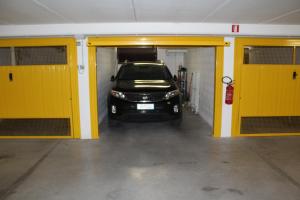 a car is parked in a garage with yellow doors at AdryHouse in Grado