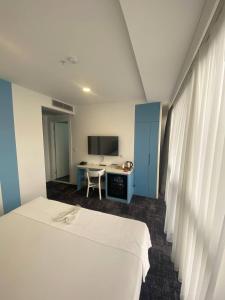 a room with a bed and a desk and a television at No25 Hotels in Çorlu