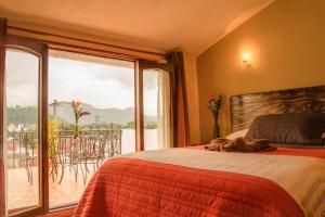 1 dormitorio con 1 cama y vistas a un balcón en Hotel Posada Dominnycos en San Cristóbal de Las Casas