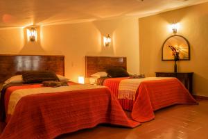 a hotel room with two beds and a mirror at Hotel Posada Dominnycos in San Cristóbal de Las Casas