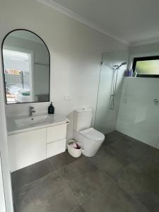 une salle de bains avec toilettes, lavabo et miroir dans l'établissement WARM Sunlit Sustainable north facing Studio, à Hawker 29 autres photos