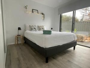 une chambre avec un grand lit et une grande fenêtre dans l'établissement WARM Sunlit Sustainable north facing Studio, à Hawker