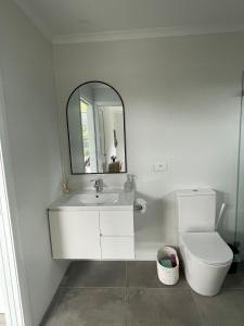une salle de bains avec lavabo, toilettes et miroir dans l'établissement WARM Sunlit Sustainable north facing Studio, à Hawker