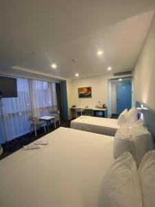 a bedroom with a large white bed and a desk at No25 Hotels in Çorlu