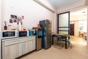 een keuken met een roestvrijstalen koelkast en een tafel bij 山邸民宿 in Taitung