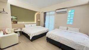een hotelkamer met twee bedden en een stoel bij 山邸民宿 in Taitung