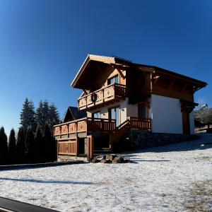 ein Haus mit Balkon in einem schneebedeckten Hof in der Unterkunft Villa Bergbliss in Jablunyzja