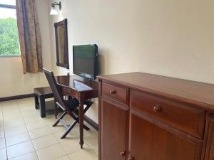 a room with a desk with a television and a desk with a chair at Golden Village Hotel  +7 photos