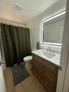 ein Badezimmer mit Waschbecken, Toilette und Spiegel in der Unterkunft New! Modern 4BR max 12 ppl, 5 mins to everything! in Reno + 29 Fotos