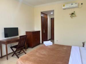 a bedroom with a desk and a bed and a computer at Golden Village Hotel in Kampong Selangan