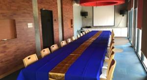 een lange blauwe tafel en stoelen in een kamer bij Klim Hotel in Buriram +184 foto's