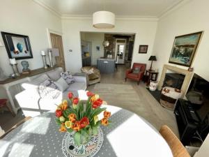 a living room with a vase of flowers on a table at Craigiebank - Lower Largo in Lower Largo