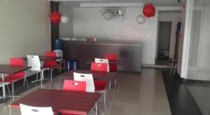 a restaurant with red and white tables and chairs at Cherry Midtown Hotel in Bahac-bahac