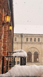 a snow covered building with a light on it at Hotel BABU in Kutaisi