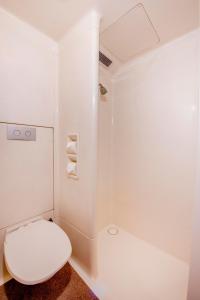 a white bathroom with a toilet and a shower at ibis Budget Wentworthville in Wentworthville