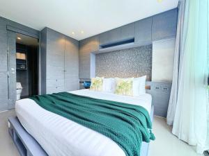 a bedroom with a large bed with a green blanket at Modern Urban Living Kamala in Kamala Beach +27 photos