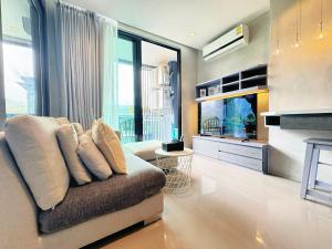a living room with a couch and a flat screen tv at Modern Urban Living Kamala in Kamala Beach