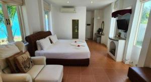 une chambre avec un lit, un canapé et une télévision dans l'établissement Ozono Resort, à Thung Faek