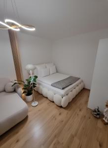 een witte kamer met een bed in het midden bij Apartmán Sárka Brezno in Brezno