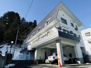 een gebouw met een busje ervoor geparkeerd bij Yuzawa house2 in Yuzawa
