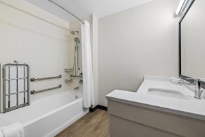 een witte badkamer met een wastafel en een bad bij Everhome Suites Rochester Greece in Rochester +73 foto's