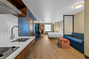 een keuken en een woonkamer met een bank en een bed bij Everhome Suites Rochester Greece in Rochester