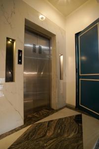 ein Bad mit einer Dusche und einer Metalltür in der Unterkunft The Food Villa in Mumbai + 13 Fotos