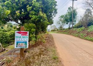 a sign on the side of a dirt road at Maemon villa แม่มอญ วิลล่า in Ban Ri So
