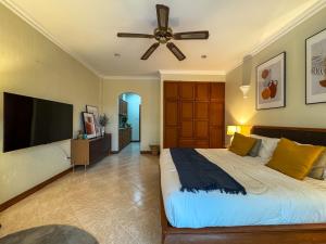 een slaapkamer met een groot bed en een plafondventilator bij View Talay Longstay in Jomtien Beach