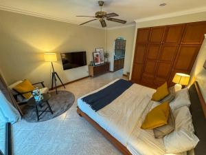 een slaapkamer met een groot bed en een televisie bij View Talay Longstay in Jomtien Beach