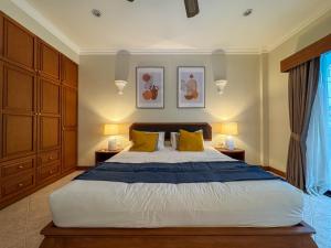 een slaapkamer met een groot bed met gele kussens bij View Talay Longstay in Jomtien Beach
