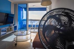a living room with a large fan in front of a living room at Balcony to the Horizon in Cartagena de Indias