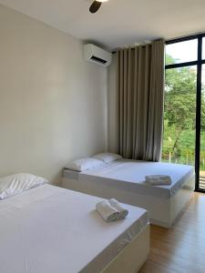 two beds in a room with a window at Lindelle Place Palawan in Puerto Princesa City +15 photos