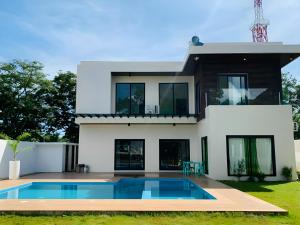 a house with a swimming pool in front of it at Lindelle Place Palawan in Puerto Princesa City