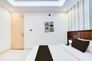 ein Schlafzimmer mit einem Bett mit einem hölzernen Kopfteil und einer Tür in der Unterkunft Townhouse Oak Ram Lala Mandir Kanpur Formerly Hotel Sun Rise in Kaliānpur