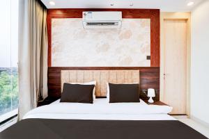 ein Schlafzimmer mit einem großen Bett und einem Fenster in der Unterkunft Townhouse Oak Ram Lala Mandir Kanpur Formerly Hotel Sun Rise in Kaliānpur + 13 Fotos