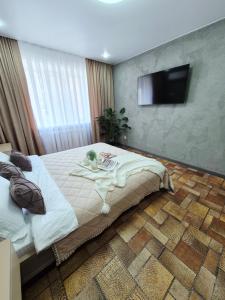 a bedroom with a bed and a flat screen tv at Отдых перед и до вылета самолёта in Astana +5 photos