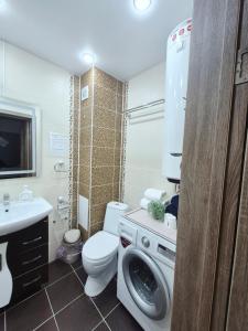 a bathroom with a washing machine and a toilet at Отдых перед и до вылета самолёта in Astana