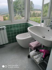 La salle de bains est pourvue d'un lavabo, d'une baignoire et de fenêtres. dans l'établissement B&B MASSERIA U Saliére, à Satriano di Lucania