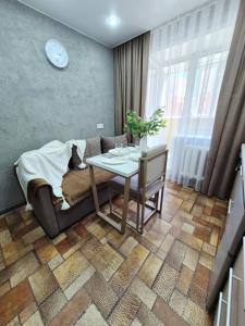 a living room with a table and a couch at Отдых перед и до вылета самолёта in Astana