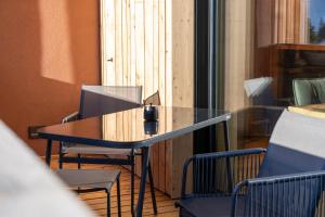 a glass table and chairs on a balcony at Lodge 53 in Breitenwang